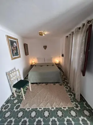 a bedroom with a bed and a chair at Riad Todra in Marrakech