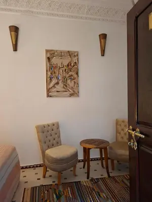 a bedroom with a bed and a painting on the wall at Riad Todra in Marrakech