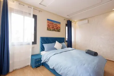 a bedroom with a blue bed and a window at family pool apartment in Marrakech