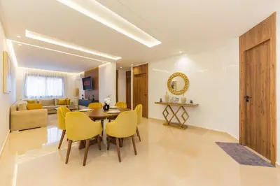 a living room with a table and yellow chairs at family pool apartment in Marrakech