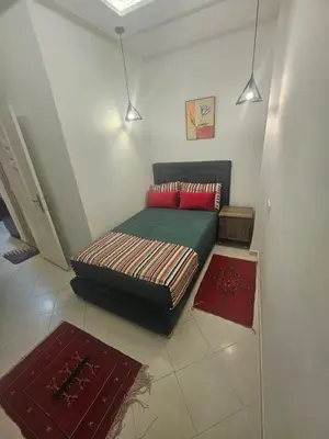 a bed in a room with two red rugs at the Heart of Marrakech Your Private Oasis in Marrakech