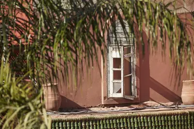 an open window on the side of a building with plants at Riad Les Jardins d'Henia in Marrakech