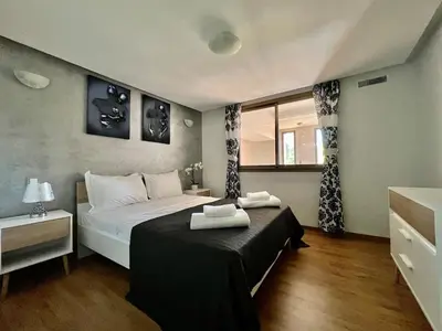 a bedroom with a large bed and a window at Beautiful Duplex Fast Wi-Fi Terrace Pool in Marrakech