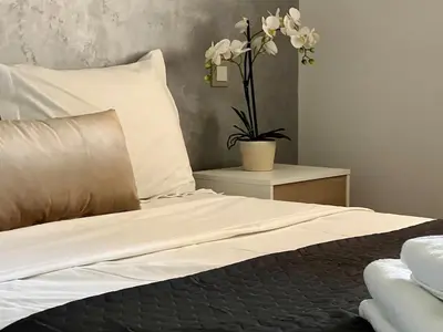 a bed with white sheets and a plant on a table at Beautiful Duplex Fast Wi-Fi Terrace Pool in Marrakech