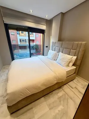 a large bed in a room with a large window at Le Nid Hermès in Marrakech