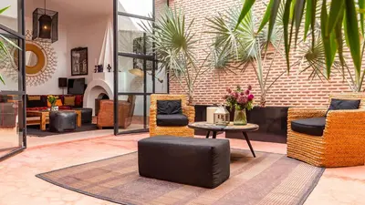 a lobby with couches and a table and chairs at Dar 118, 3ch, hammam, piscine, rooftop, personnel in Marrakech