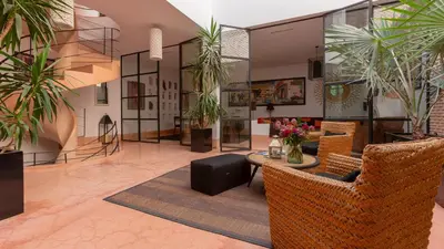 a lobby with chairs and a table and potted plants at Dar 118, 3ch, hammam, piscine, rooftop, personnel in Marrakech