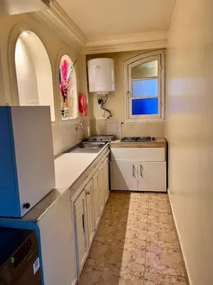 a small kitchen with white cabinets and a window at Apartment in the center of Marrakesh in Marrakech