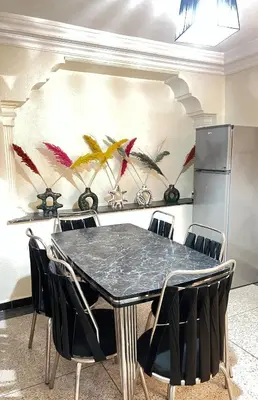 a dining room with a black table and chairs at Apartment in the center of Marrakesh in Marrakech