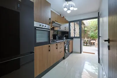 a kitchen with wooden cabinets and a stove top oven at Super duplexe en plein Marrakech in Marrakech