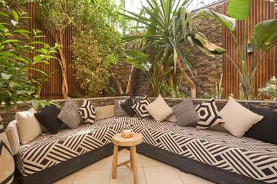 a couch with pillows on a patio with plants at Super duplexe en plein Marrakech in Marrakech