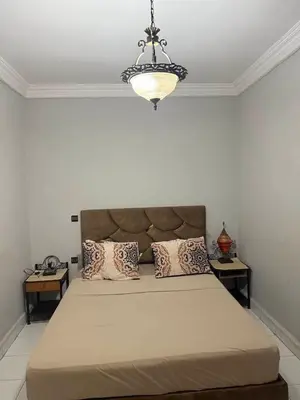 a bedroom with a large bed with pillows and a chandelier at Apartment in the heart of Gueliz in Marrakech
