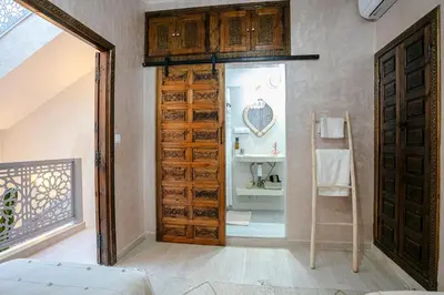 a large wooden door in a room at Riad 3ch, proche Médina, résidence avec piscines in Marrakech
