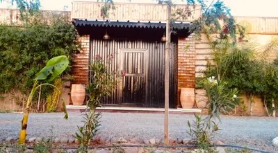 a brick building with a door with a balcony at Riad Eglantine in Touggana