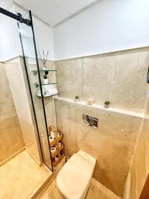 a bathroom with a toilet and a glass shower at Marrakech apartment with pool - Pearl Garden in Marrakech