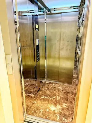 a glass door of a elevator in a building at Marrakech apartment with pool - Pearl Garden in Marrakech