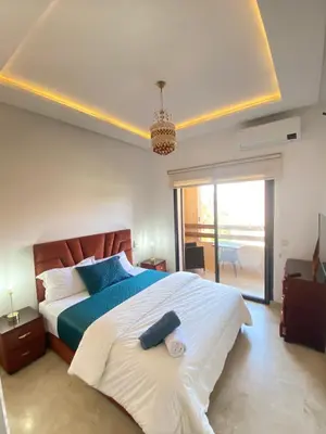 a bedroom with a large bed with blue pillows at Appartement lumineux & élégant avec accès piscine in Marrakech