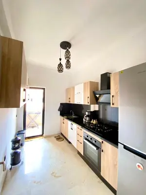 a kitchen with a stove and a refrigerator at Appartement lumineux & élégant avec accès piscine in Marrakech