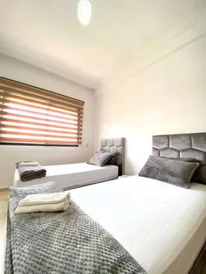 a bedroom with two beds and a window at Appartement lumineux & élégant avec accès piscine in Marrakech