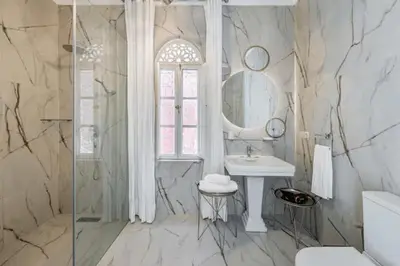 a white bathroom with a sink and a mirror at Riad Byerd in Marrakech