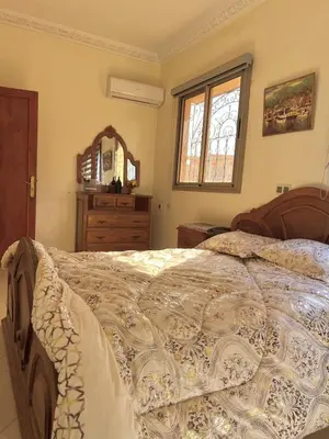 a bedroom with a large bed with a dresser and a window at Modern apartment, 10 minutes from the airport in Marrakech