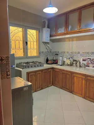 a large kitchen with wooden cabinets and a sink at Modern apartment, 10 minutes from the airport in Marrakech