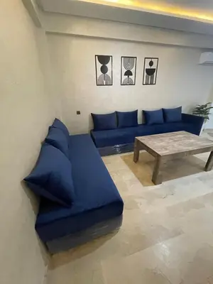 a living room with a blue couch and a table at 3wina immobilier in Marrakech