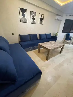 a living room with a blue couch and a table at 3wina immobilier in Marrakech