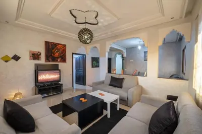 a living room with a couch and a tv at Dar Yassan in Marrakech