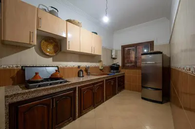 a kitchen with wooden cabinets and a stainless steel refrigerator at Dar Yassan in Marrakech