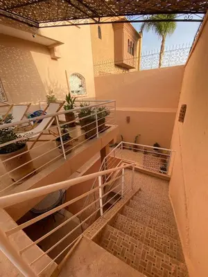 a staircase in a building with tables and potted plants at Peaceful Retreat with pool in Marrakech
