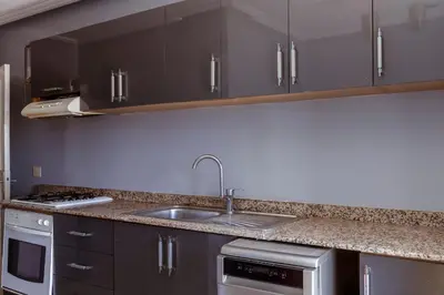 a kitchen with a sink and a stove and cabinets at Chic et climatisé au centre de gueliz in Marrakech