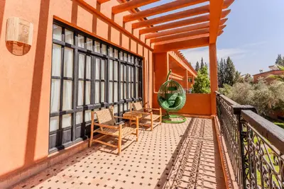 a balcony of a house with chairs and a fence at MVIEW Villas in Marrakech