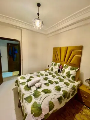 a bedroom with a bed with a green and white comforter at Agréable, cosy, proche du centre in Marrakech