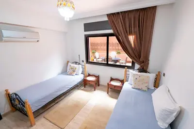 a bedroom with two beds and a window at Appartement Jasmin in Marrakech