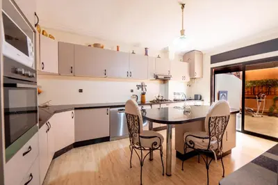 a kitchen with a table and chairs in it at Appartement Jasmin in Marrakech