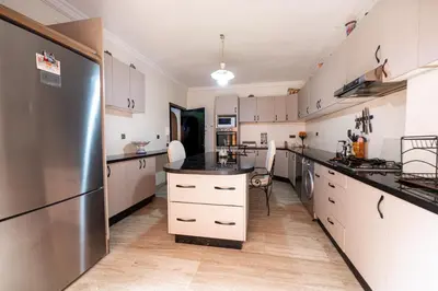 a kitchen with white cabinets and a stainless steel refrigerator at Appartement Jasmin in Marrakech