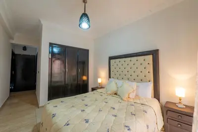 a bedroom with a large bed and two night stands at Appartement Jasmin in Marrakech