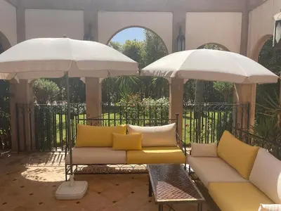 a couch and two umbrellas on a patio at Amour de Nuits in Douar Caïd Layadi
