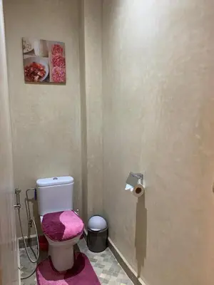 a bathroom with a toilet with a pink towel at Amour de Nuits in Douar Caïd Layadi