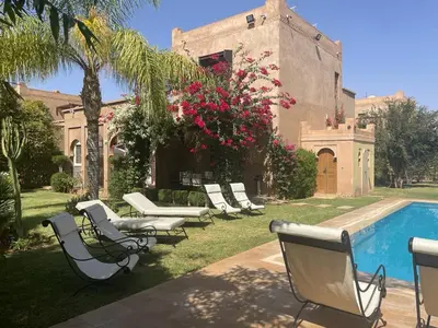 a group of chairs sitting next to a swimming pool at Amour de Nuits in Douar Caïd Layadi
