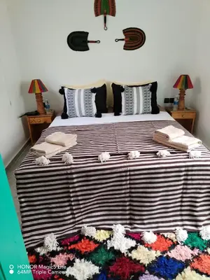 a bedroom with a large bed with flowers on the floor at ATHIKA Hostel in Marrakech