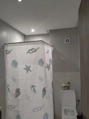 a bathroom with a shower curtain with a toilet at Luxury Stay Nour Prestige Residence, Gueliz in Marrakech
