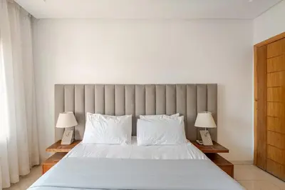 a bedroom with a large bed with two lamps at Prestige Hivernage centr de marrakech in Marrakech