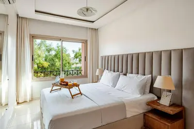 a bedroom with a large bed and a window at Prestige Hivernage centr de marrakech in Marrakech