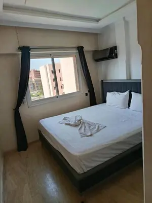 a bedroom with a large bed with a window at Kamal Atoumi in Marrakech