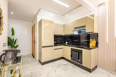 a large kitchen with black counter tops and appliances at Gueliz Chic stay next to Carré Eden in Marrakech