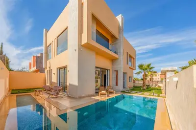 a house with a swimming pool in front of a house at Villa moderne à 5 mins du centre-ville de Marrakech in Marrakech