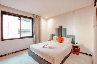a bedroom with a bed and a large window at Modern Flat Gueliz Near Medina Netflix AC in Marrakech