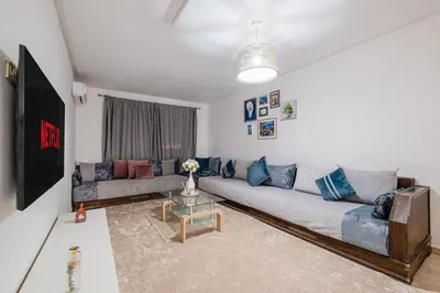 a living room with a couch and a table at 2BR Retreat in Hivernage Center with Pool, Balcony & Parking in Marrakech